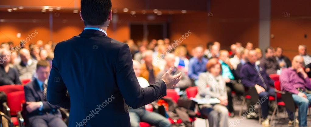 Motivational speaker on stage addressing an audience