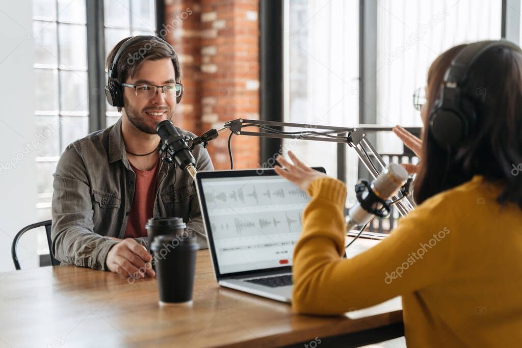 Podcast host speaking into a microphone with headphones on